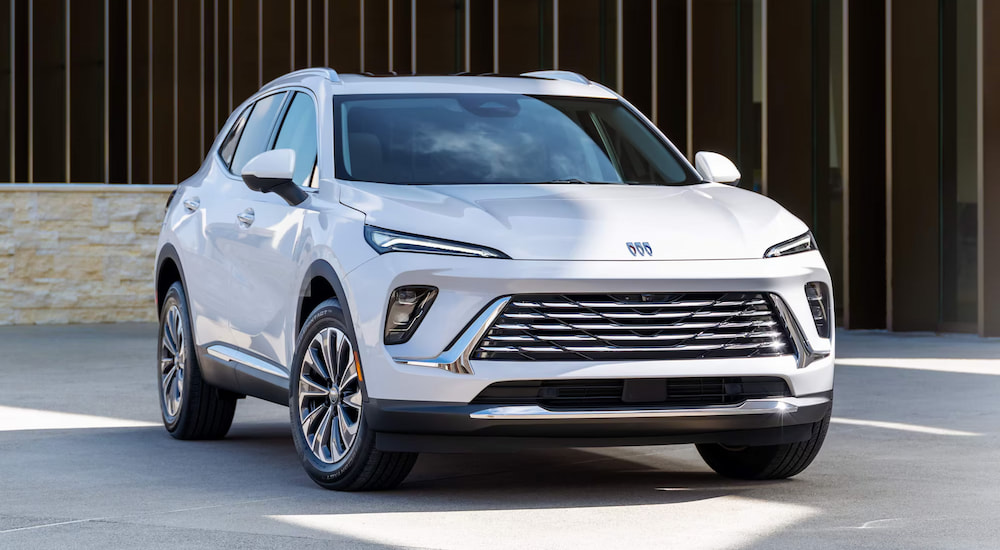 A white 2025 Buick Envision parked outside of a building and angled right.