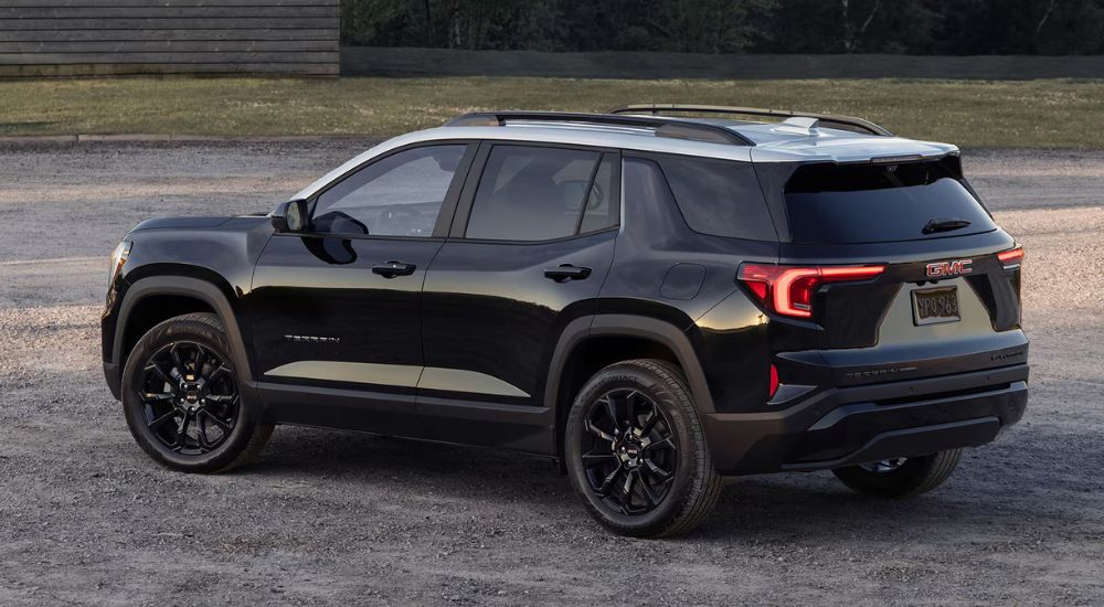 Rear overhead view of a black 2025 GMC Terrain Elevation parked on gravel.