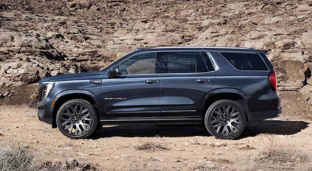 A blue 2025 GMC Yukon XL parked off-road after visiting a GMC dealer near Plymouth.