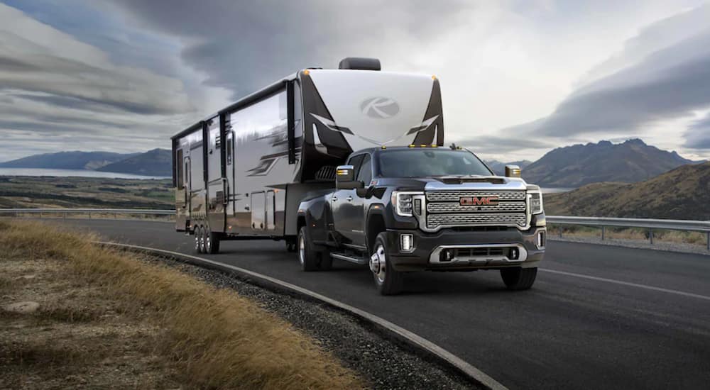 A black 2021 GMC Sierra 3500 towing a camper behind