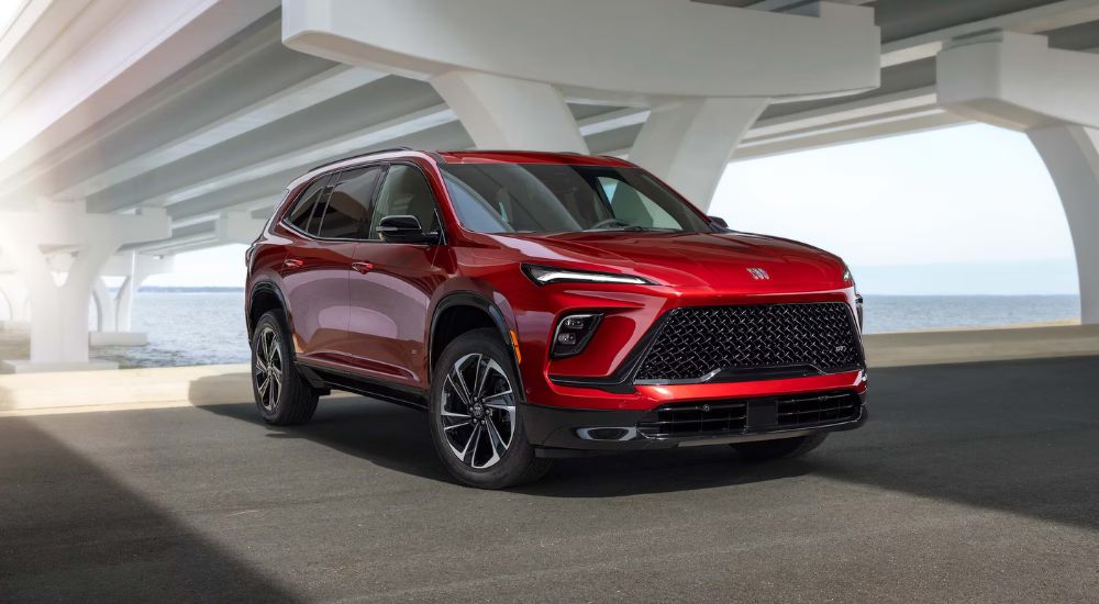 A red 2026 Buick Enclave ST shown parked under a bridge.
