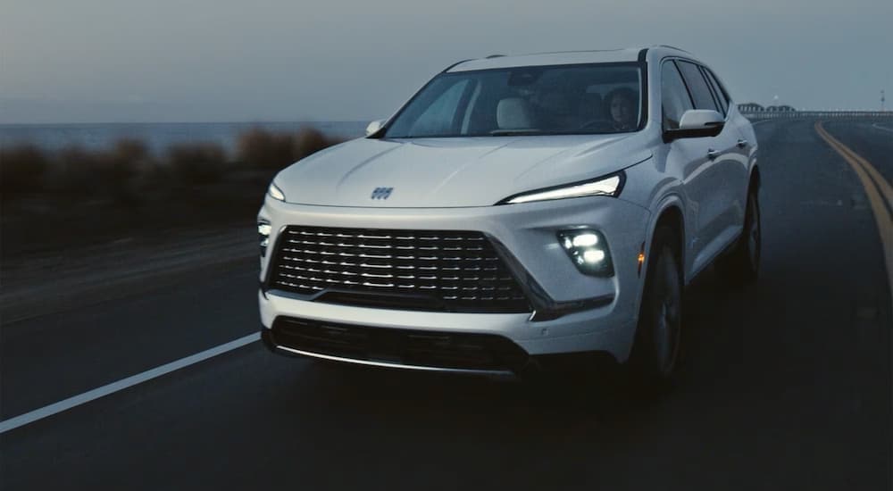 A white 2026 Buick Enclave driving on a highway.