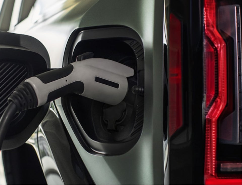 Close up of charging port with charger plugged in on a GMC Hummer EV SUV - Lupient Buick GMC in Golden Valley MN