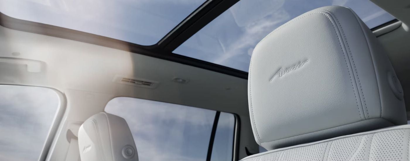 The front seats and sunroof inside of a 2026 Buick Enclave Avenir.