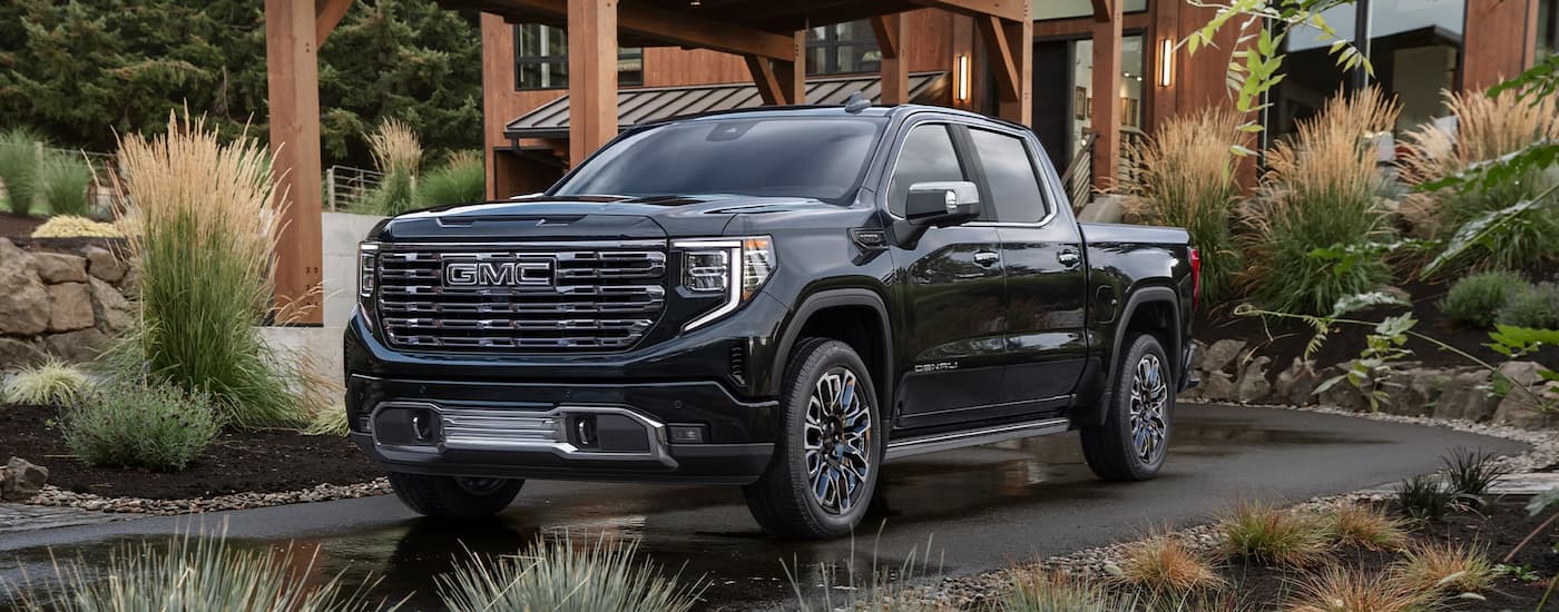 Blue 2026 GMC Sierra 1500 driving down a road.