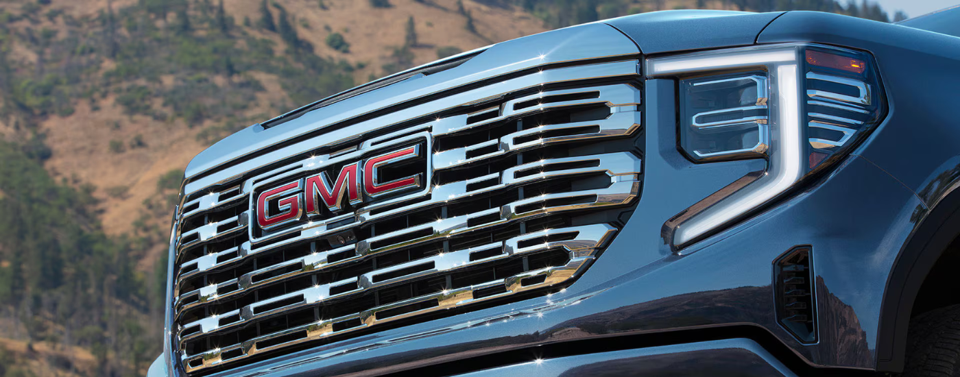 Chrome grille and red badging on a blue 2026 GMC Sierra 1500