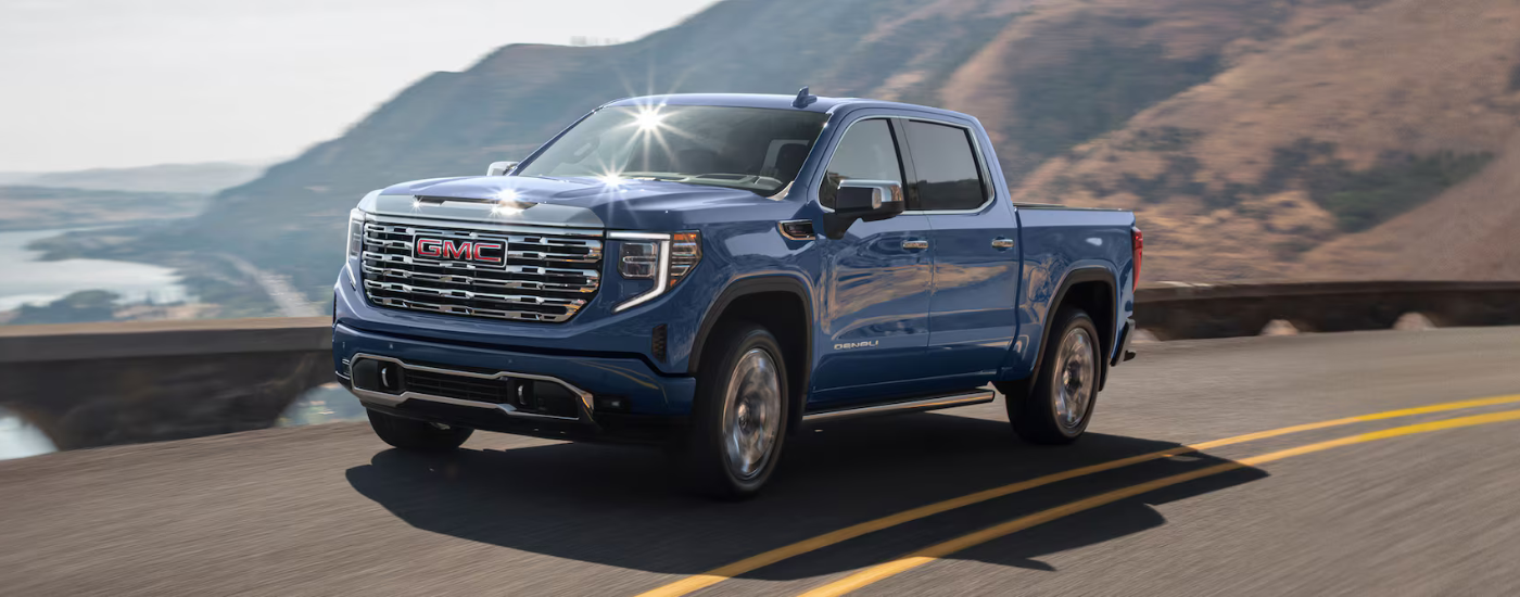 Blue 2026 GMC Sierra 1500 Denali driving along the coast