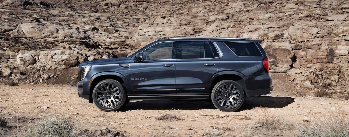 Side of a grey 2026 GMC Yukon parked off-road.