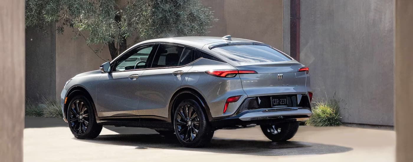 A rear view of a silver 2025 Buick Envista while parked near a Buick dealer.