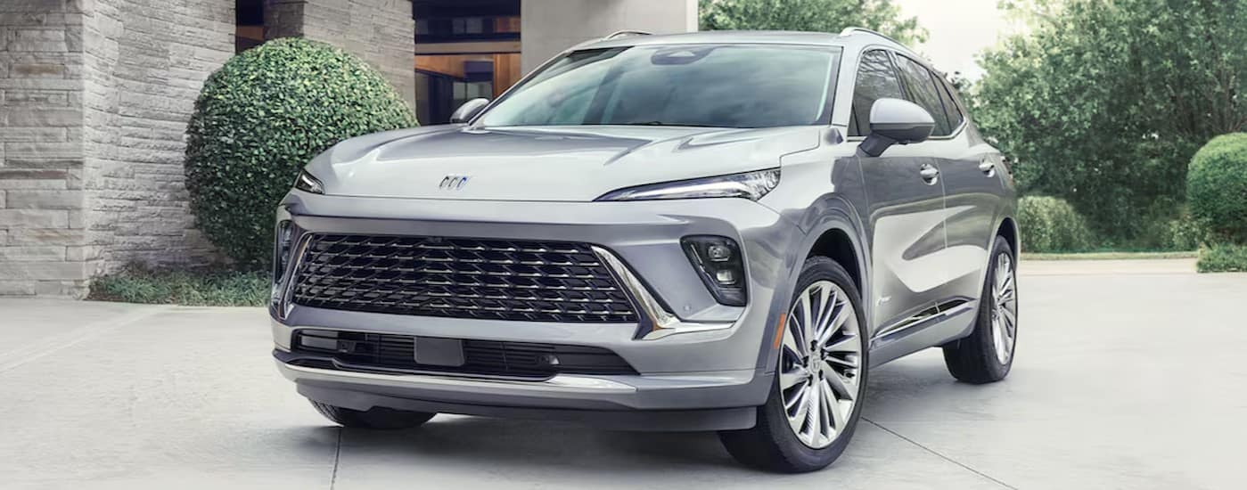 A silver 2024 Buick Envision Avenir parked at a Buick dealer near Bloomington.